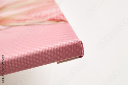 Detailed close-up of a pink photo canvas print with a gallery wrap edge, highlighting the tight, professional stretching and textured surface on a white background