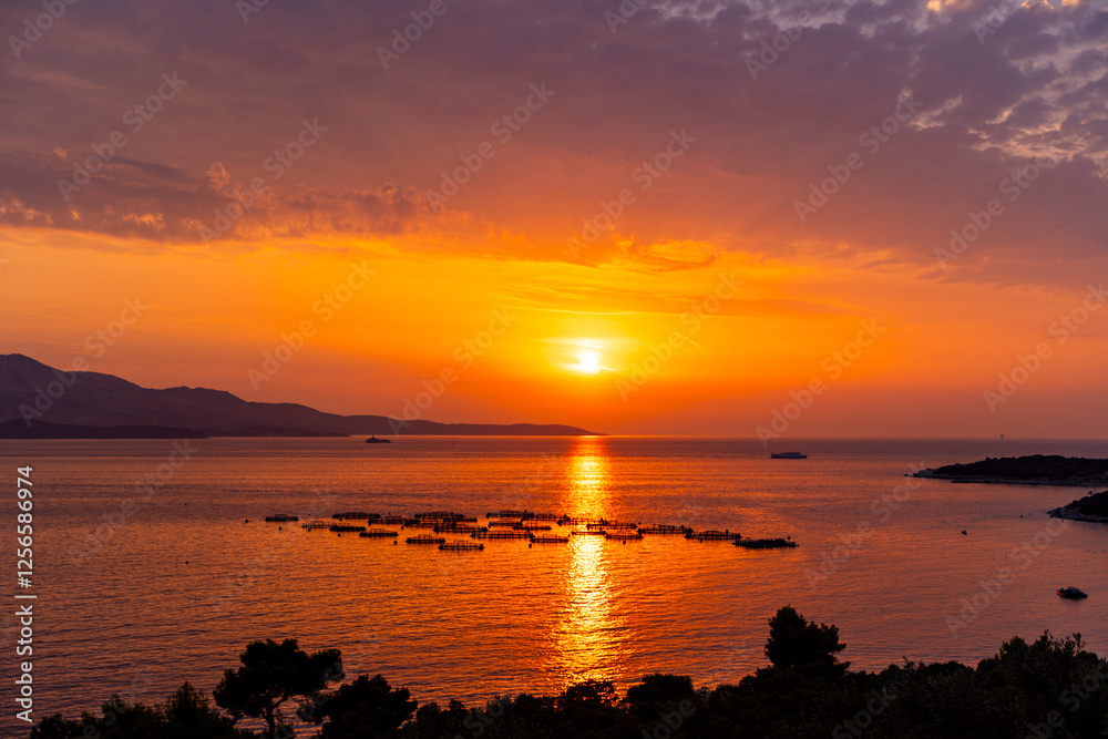 Fototapeta premium sunset at the beachAlbania, Vlorë County, Ksamil - 18 August 2024 - The sky of Ksamil at sunset is illuminated by the heat of the Sun