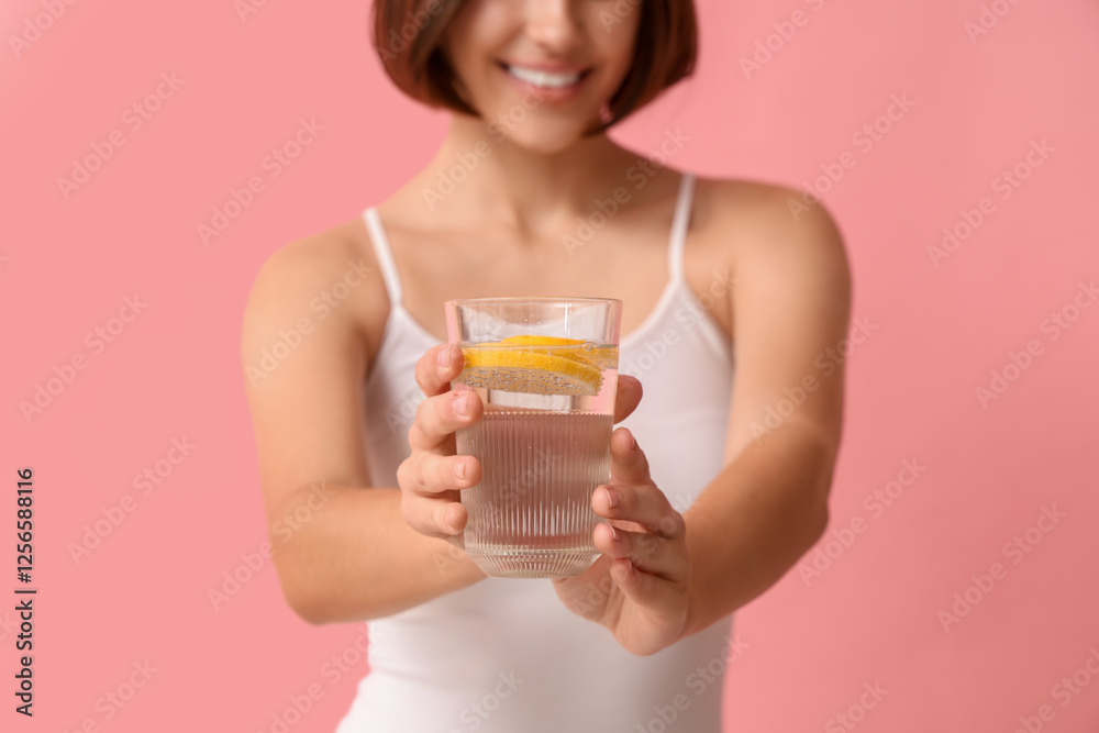 Young woman with glass of infused water on pink background Young woman with glass of infused water on pink background