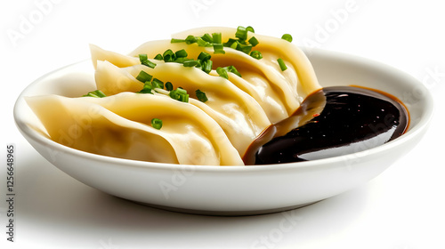 A delicious plate of dumplings served with a rich dipping sauce, garnished with fresh herbs for added flavor. photo