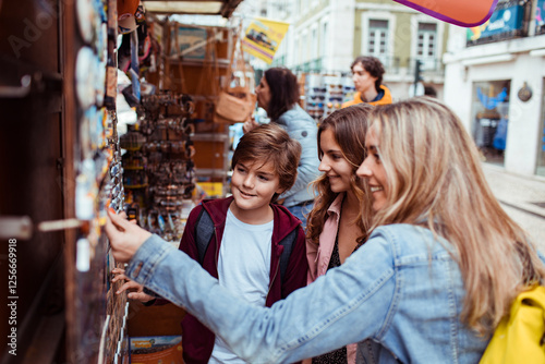 Happy mother and children shopping for souvenirs at a street market