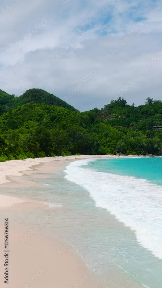White sandy beach with turquoise waves, surrounded by dense green foliage. Anse Intendance. Seychelles, Mahe. White sandy beach with turquoise waves, surrounded by dense green foliage. Anse Intendance. Seychelles, Mahe.