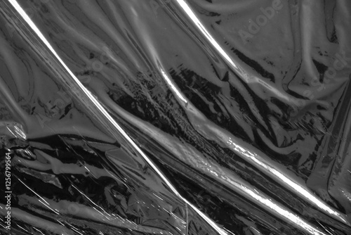 Black plastic stretch wrap film as background, top view
