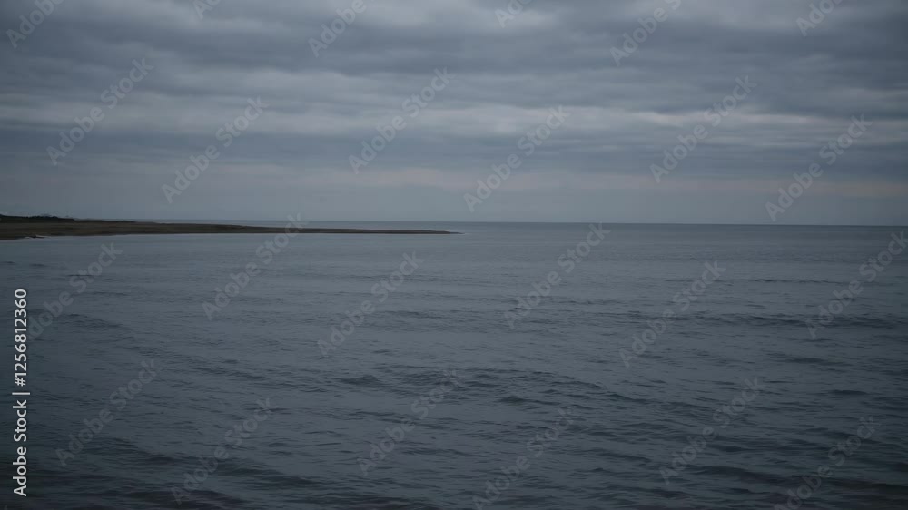 A serene seascape video with a wide-angle view capturing the vast ocean under a cloudy sky, emphasizing tranquility and open space. Video. A serene seascape video with a wide-angle view capturing the vast ocean under a cloudy sky, emphasizing tranquility and open space. Video.