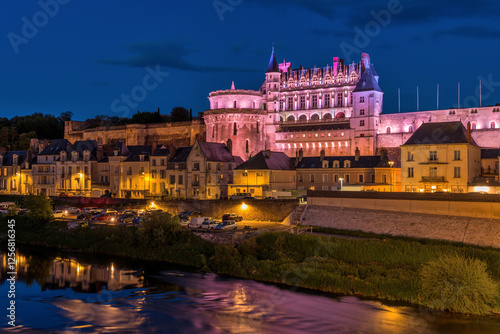 Amboise at Night - A panoramic dusk view of historic town Amboise at side of River Loire, with illuminated royal castle Chateau d'Amboise towering at hilltop. Amboise, Loire Valley, France.