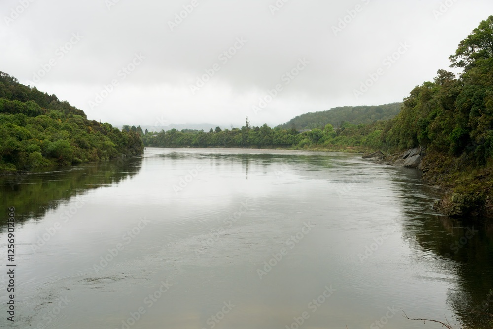Obraz premium The Grey River on a Cloudy Day – Calm Water Landscape