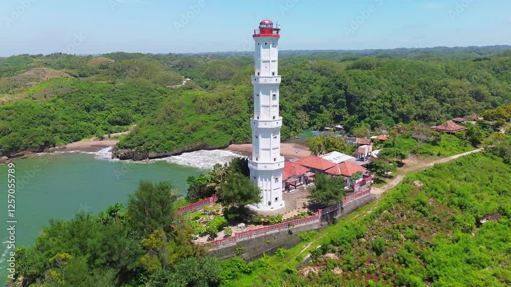 Aerial drone view Lighthouse or mercusuar on a coral hill on Baron beach, Gunung Kidul, Yogyakarta, which is also a tourist destination and traditional fishing port Aerial drone view Lighthouse or mercusuar on a coral hill on Baron beach, Gunung Kidul, Yogyakarta, which is also a tourist destination and traditional fishing port