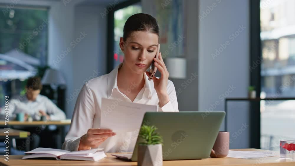 Dissatisfied executive quarrelling cellphone holding documents in office closeup Dissatisfied executive quarrelling cellphone holding documents in office closeup
