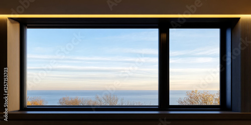 Expansive ocean view from a modern window with serene skies at dusk