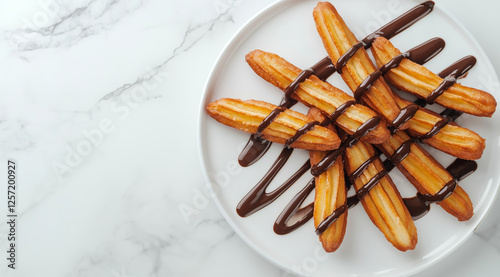 Top view of delicious churros drizzled with rich chocolate sauce on a white plate, placed on a marble surface photo