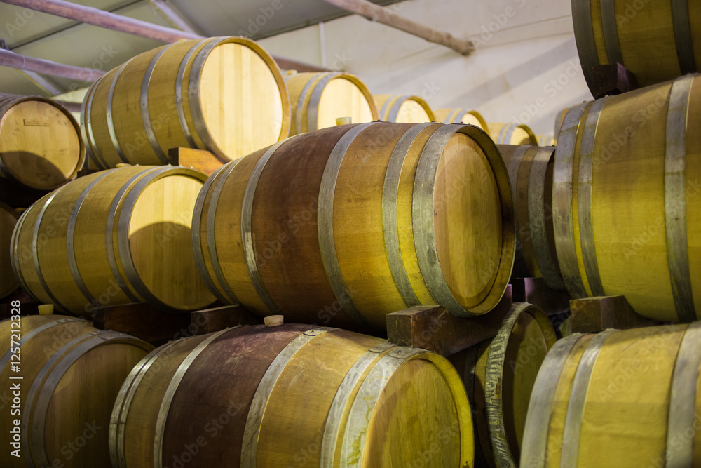 Stacked wooden wine barrels in a winery cellar, highlighting traditional wine aging and storage practices in a controlled environment. Stacked wooden wine barrels in a winery cellar, highlighting traditional wine aging and storage practices in a controlled environment.