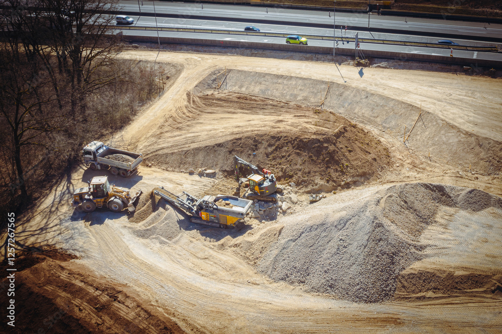 Material Landfill with Heavy Machinery Processing Sand and Gravel Near Highway Construction Site. Aerial View of Construction Material Landfill with Heavy Machinery Processing Sand and Gravel Near Highway Construction Site. Aerial View of Construction
