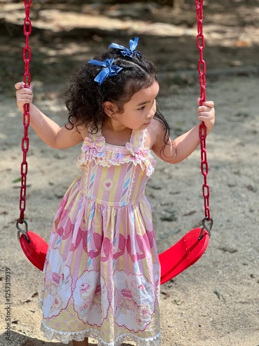 Portrait of a little girl on a swing in the park