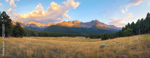 Sunset panorama Mountain range vista over golden meadow