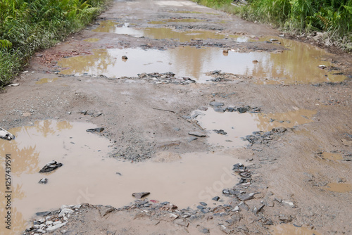 Damaged potholed roads that are flooded after rain. hampering village transportation access to the city. Kubu Raya, West Kalimantan - December 14, 2024