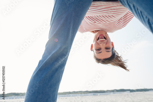 Playful woman enjoying at beach on sunny day