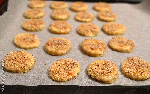 Obraz na płótnie Baked cookies with crunchy topping prepared on parchment paper in a cozy kitchen w salonie