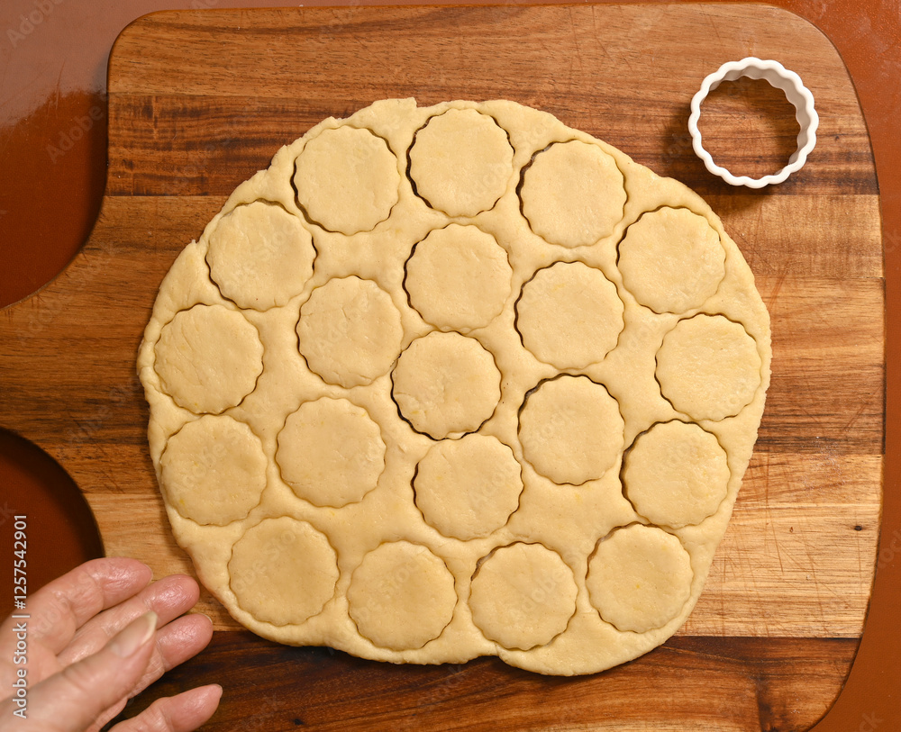 Perfectly cut cookie dough circles ready for baking on a wooden surface