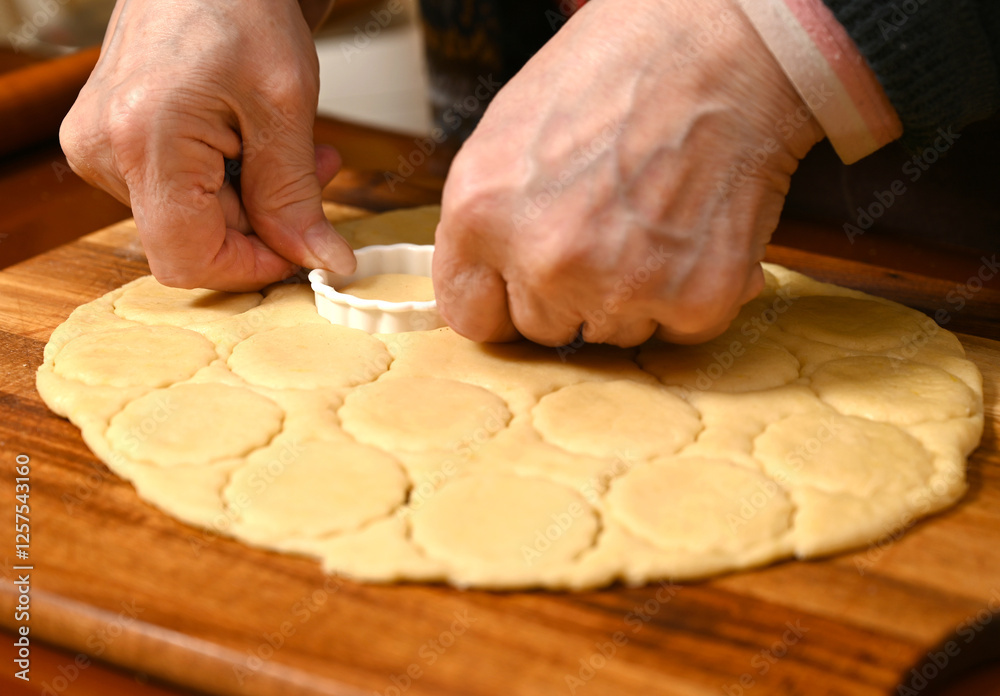 Baking cookies in a cozy kitchen with hands shaping dough for a family recipe