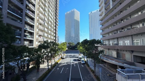 A modern cityscape of Harumi, Tokyo, showing tall buildings and a wide street photo