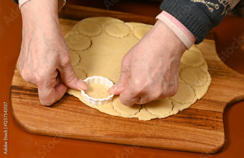 Obraz na płótnie Baking cookies in a cozy kitchen with hands shaping dough for a family recipe w salonie