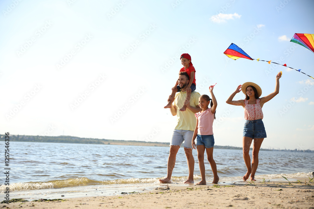 © New Africa - Happy parents and their children playing with kites on beach near sea. Spending time in nature