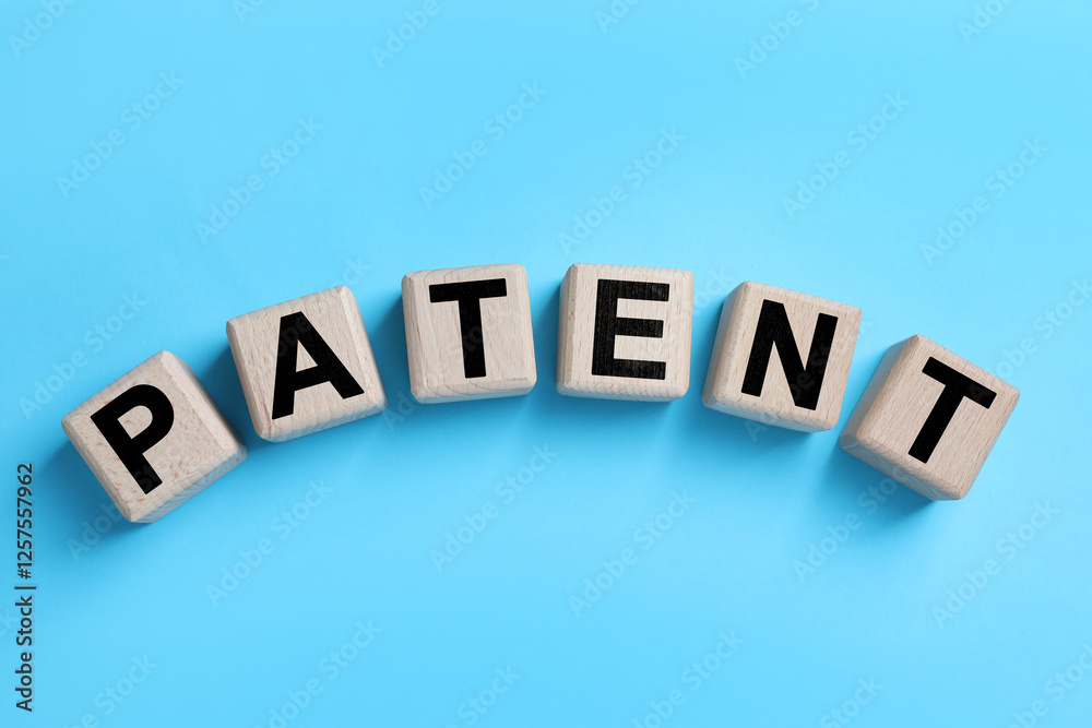 Obraz premium License. Word Patent made of wooden cubes with letters on light blue background, top view