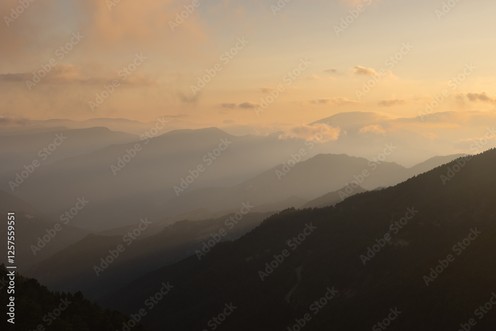 Misty mountain range with haze and clouds at sunset. Misty mountain range with haze and clouds at sunset.