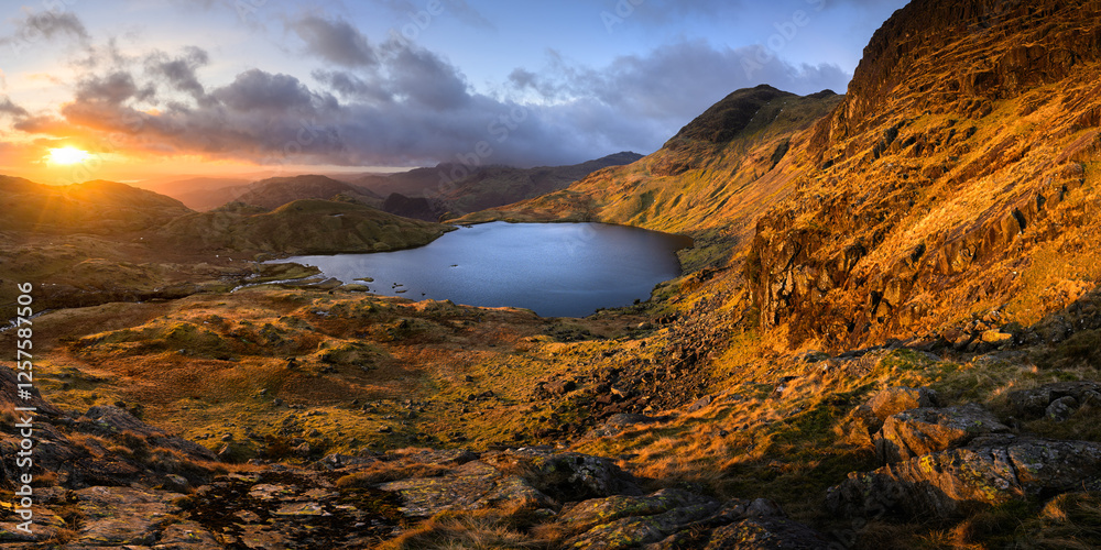 Lake District mountains at sunrise with panoramic view of Stickle Tarn, overlooking Pavey Ark & Southern Fells. Lake District mountains at sunrise with panoramic view of Stickle Tarn, overlooking Pavey Ark & Southern Fells.