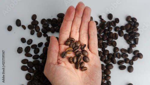  Coffee beans on the palm of the hand, with a coffee background