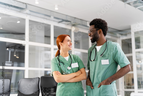 Female doctor and male colleague discussing health care strategies in hospital office