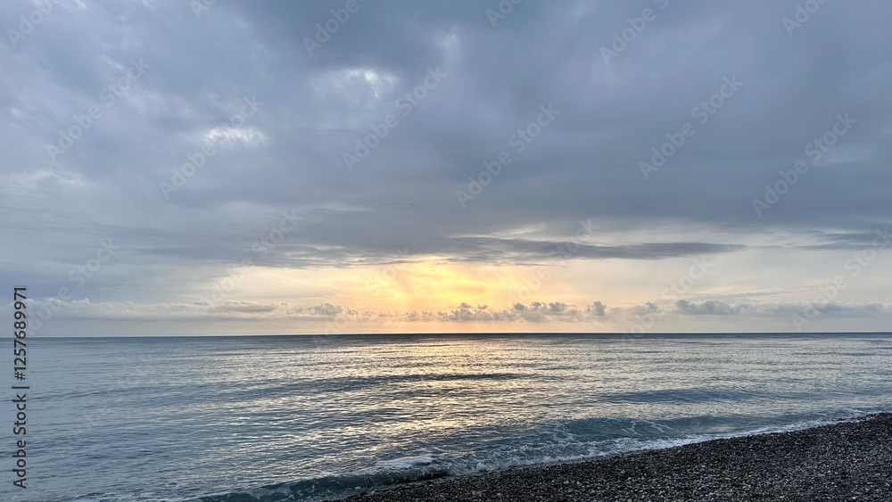 Fototapeta premium Sunset overlooking the Black Sea from a pebble beach in Abkhazia