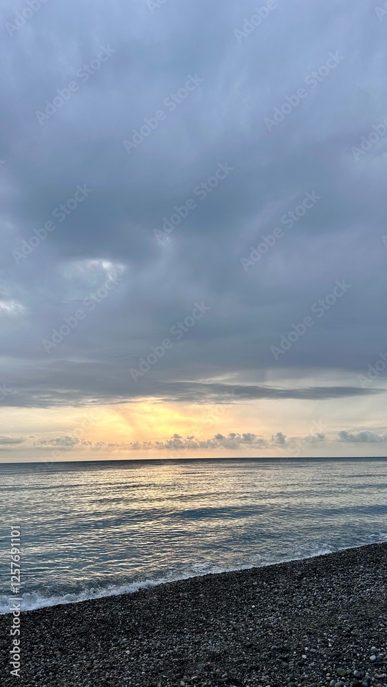 Obraz premium Sunset overlooking the Black Sea from a pebble beach in Abkhazia