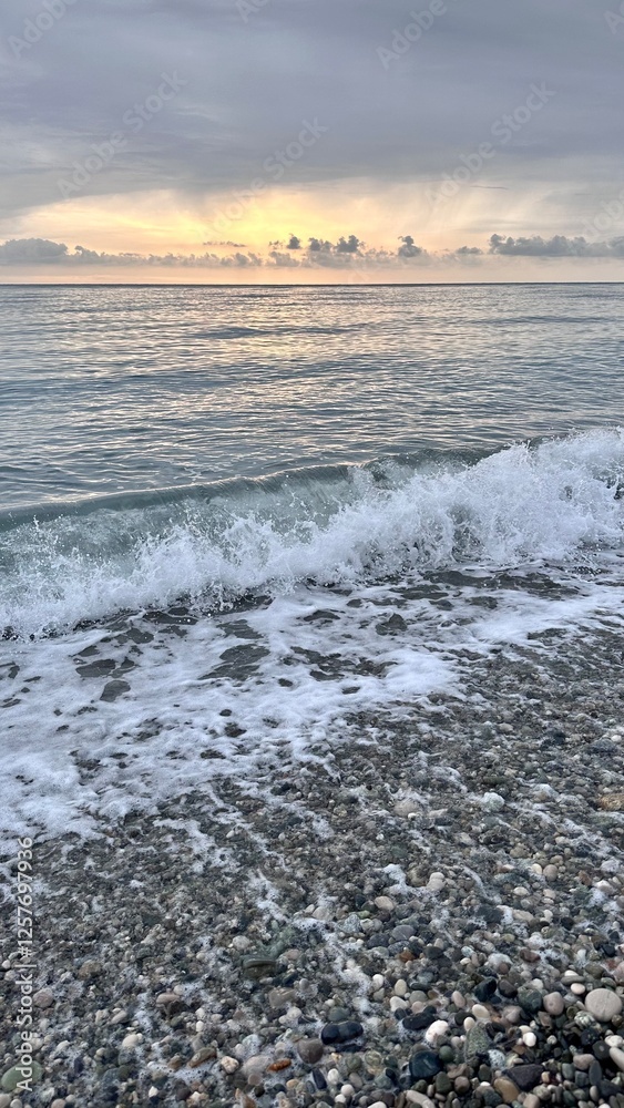 Fototapeta premium Sunset overlooking the Black Sea from a pebble beach in Abkhazia