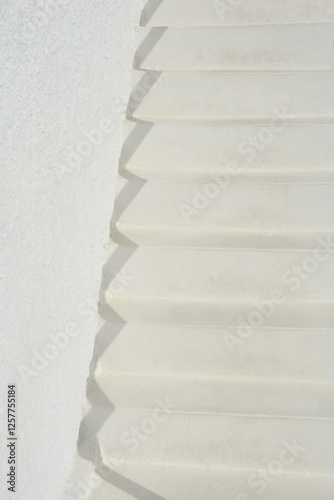 A minimalist shot of white steps with distinct shadows cast against a white wall, creating a clean, architectural abstract