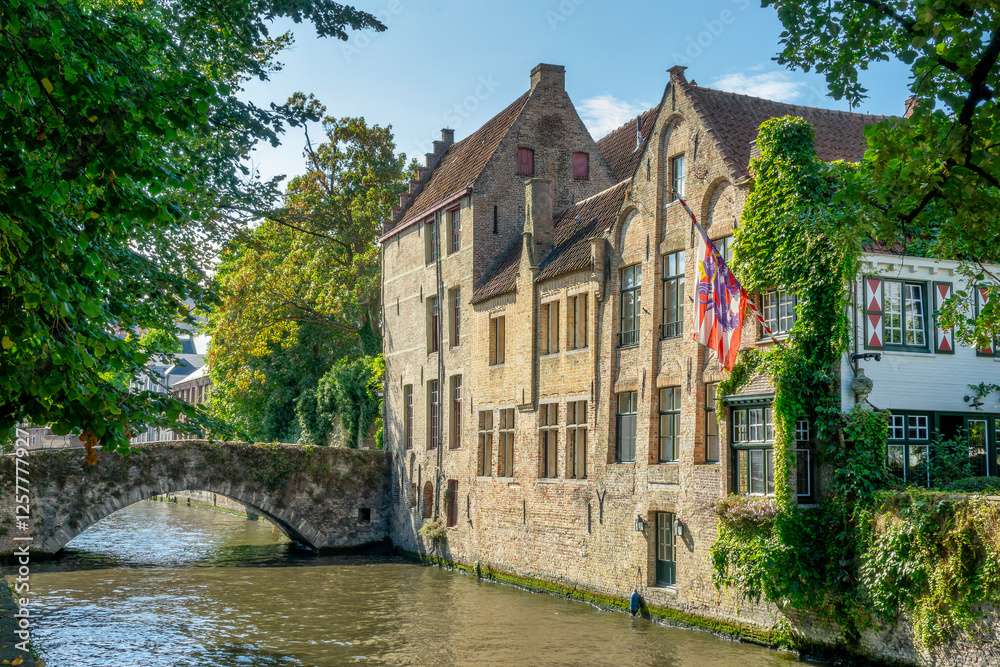 Old stone bridge on a water canal and medieval flemish architecture, Bruges cityscape, Belgium