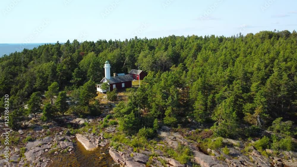 Atemberaubender Drohnenflug über einen malerischen Leuchtturm am Vänernsee in Schweden bei Sonnenuntergang – Spiegelndes Wasser und idyllische Landschaft in goldenem Licht