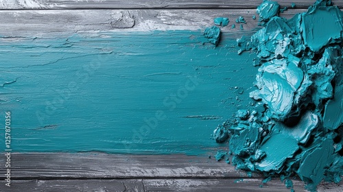 Teal paint stroke and textured acrylic paint dollops on a dark grey wooden background.