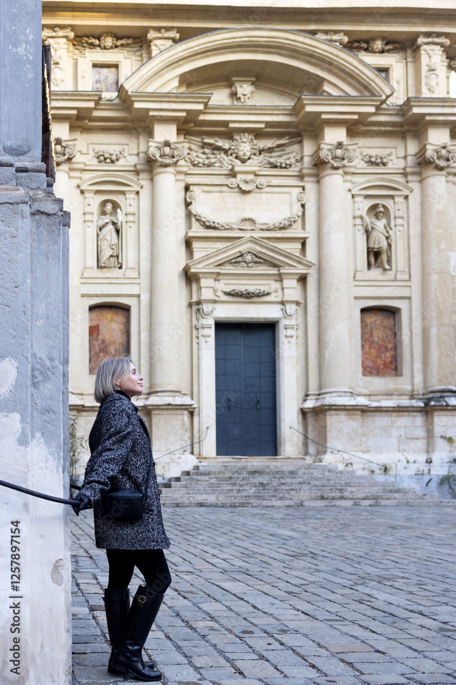 During a walk, woman inspects an ancient building decorated with sculptures During a walk, woman inspects an ancient building decorated with sculptures