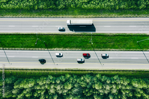 Obraz na płótnie Aerial drone view of highway asphalt road with cars and trucks driving through green summer woods. Cargo delivery logistic concept w salonie