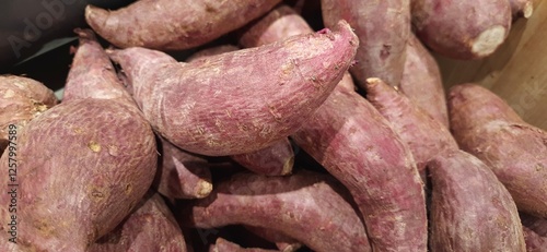 Purple sweet potatoes or ubi cilembu background for sale on the market in Indonesia photo