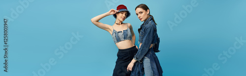 Canvas Print Twins showcasing unique fashion styles against a vibrant blue background at a tr
