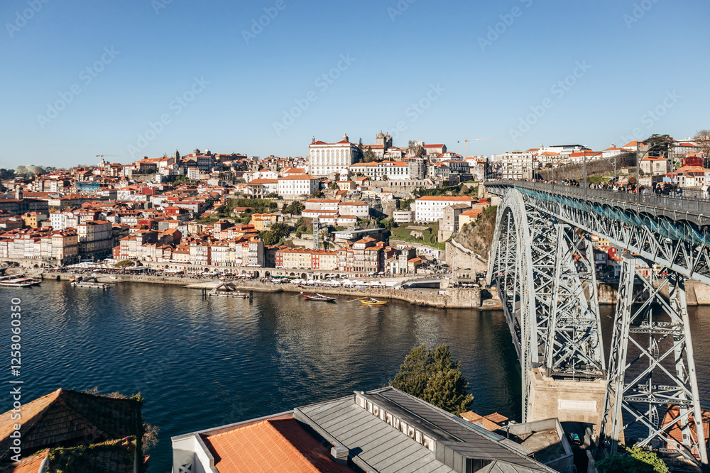 Obraz premium Porto, Portugal - December 28, 2024: View of the Douro River and the picturesque Ribeira district, a UNESCO World Heritage site