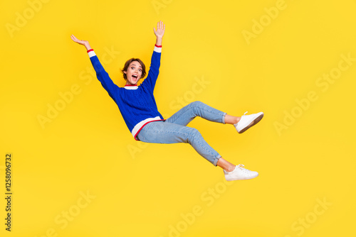 Full length photo of shiny cheerful lady dressed knitted sweater rising hands arms falling down isolated yellow color background photo