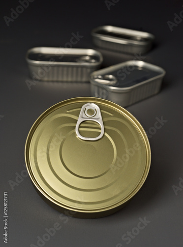 Close up of metallic food cans with pull tab lids on gray background