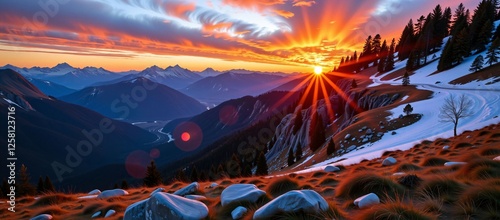 Dramatic sunset over a mountain valley with snow and colorful sky