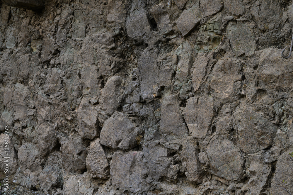 Naklejka premium Unique texture of an ancient stone wall illuminated by soft natural light in a quiet setting