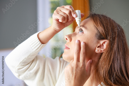 Young woman putting eye drops