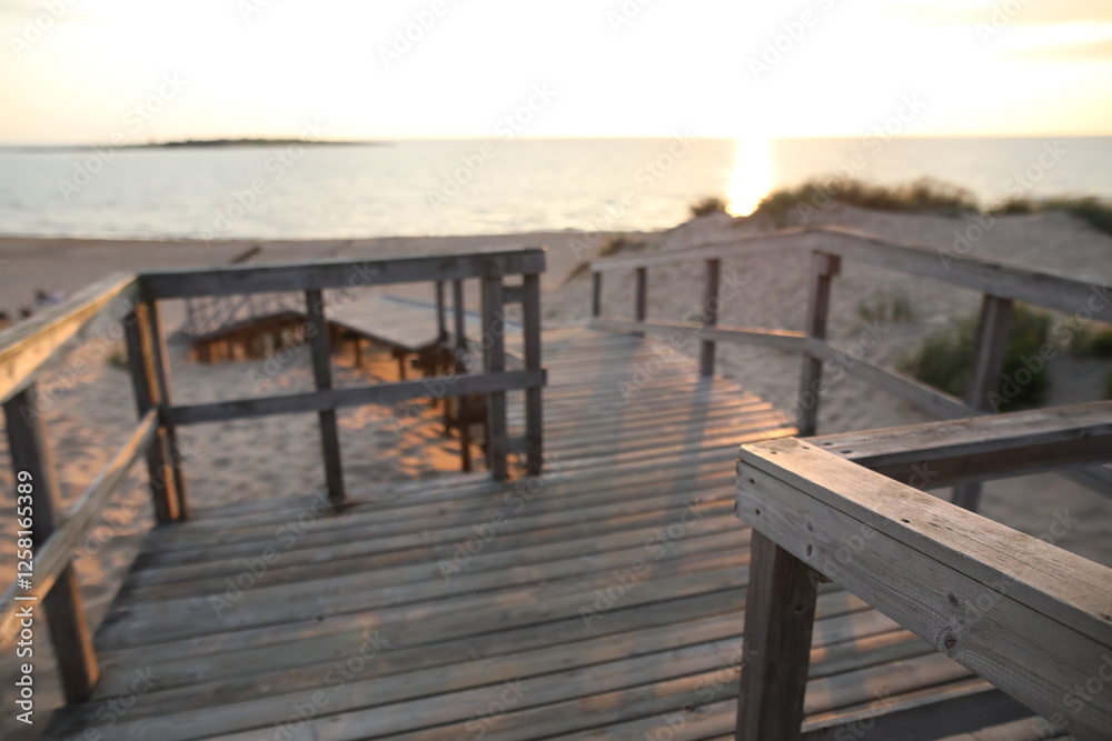 A pier heading down to the beach during sunset A pier heading down to the beach during sunset