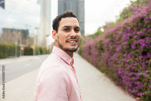 Cuban man smiling outdoors with vibrant urban background